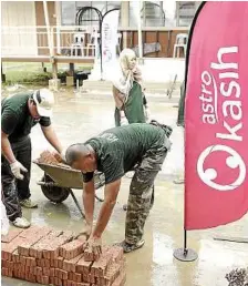  ??  ?? Working together: Astro Kasih employee volunteers lending a hand to construct the hostel building.