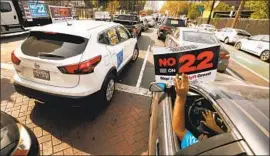  ?? Al Seib Los Angeles Times ?? UBER, Lyft and other gig companies poured money into passing Propositio­n 22, creating a carve- out from state labor law. Above, a 2020 no- on- 22 protest.