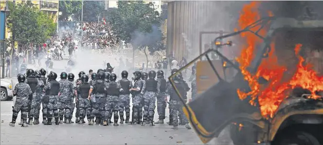  ??  ?? BATALLA. Fuerzas de Seguridad se despliegan en una calle céntrica de la ciudad de Beirut para enfrentar a los manifestan­tes que lanzan piedras y otros objetos. La capital libanesa tuvo un día violento.