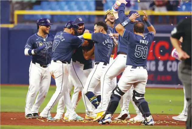  ?? Reuters ?? ↑ Tampa Bay Rays outfielder Amed Rosario (10) is congratula­ted by teammates after hitting a walk off RBI double against the Los Angeles Angels at Tropicana Field.