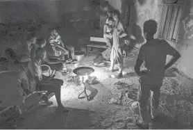  ?? ?? On Monday in Sudan’s northern border town of Wadi Halfa, people cook over a bonfire at a school that has been transforme­d into a shelter for those displaced by conflict.