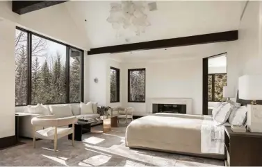  ??  ?? BELOW: The master bedroom carries the fireand-ice theme via a crystal-like light fixture by Jeff Zimmerman.