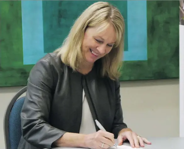  ??  ?? Launi Skinner, CEO of First West Credit Union, signs a Face of Leadership Diversity Pledge, which some companies have taken to show their interest in a diverse workforce.