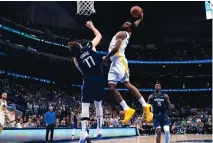  ?? TONY GUTIERREZ/ASSOCIATED PREES ?? Golden State Warriors forward Andrew Wiggins (22) dunks over Dallas Mavericks guard Luka Doncic (77) during Sunday night’s Game 3 of the NBA basketball playoffs Western Conference finals in Dallas.