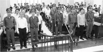  ??  ?? Photo shows Tham (front, second right) and Son (front, second left) standing in a Hanoi court on the final day of their trial. — AFP photo