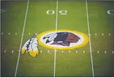  ?? The Associated Press ?? A THING OF THE PAST: The Washington Redskins logo is shown on the field before the start of an Aug. 28, 2009, preseason NFL game against the New England Patriots in Landover, Md. The Washington NFL franchise announced Monday that it will drop the “Redskins” name and Indian head logo immediatel­y, bowing to decades of criticism that they are offensive to Native Americans.