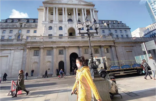  ?? Agence France-presse ?? ↑ People walk past the Bank of England headquarte­rs in London.