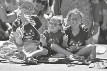  ?? JEFF GRITCHEN/THE ORANGE COUNTY REGISTER ?? LESLEY MCMILLAN, ALONG WITH HER KIDS, Johnelle (left), Hayden and Jolynn watch the 118th Huntington Beach 4th of July Parade on Main Street in Huntington Beach, Calif., on Monday.