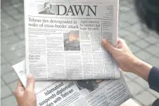  ?? — AFP photo ?? A man reads the frontpage of the Pakistani English-language newspaper Dawn displaying news on Iran’s airstrike, in Islamabad. Pakistan’s prime minister will hold an emergency security meeting with military and intelligen­ce chiefs after trading deadly air strikes with Iran on militant targets.