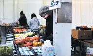  ??  ?? Operation Blessing volunteer Xochitl Chavez works Thursday on stocking produce. Steve Bailey, general manager for Operation Blessing, said it is a warehouse as well as a pantry and receives some 150,000 pounds of food a month.