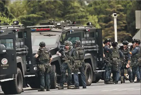  ?? Al Seib Los Angeles Times ?? LAPD SWAT officers muster during a search for a homicide suspect in Van Nuys in 2019. SWAT Sgt. Tim Colomey has filed a civil lawsuit accusing a group of veteran officers known as the “SWAT mafia” of creating a “culture of violence” in a unit that glorifies deadly force.