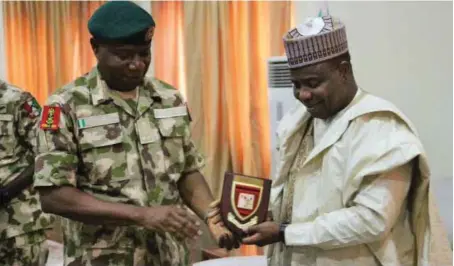  ??  ?? General Officer Commanding, Nigerian Army’s 8 Division, Sokoto, Brig-Gen SO Olabanji presenting a plaque to Sokoto State Governor, Aminu Waziri Tambuwal to commemorat­e the take off of the new division, during a visit to Sokoto Government House...