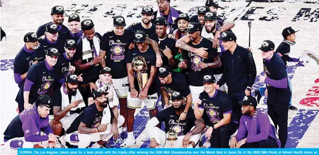  ??  ?? FLORIDA: The Los Angeles Lakers pose for a team photo with the trophy after winning the 2020 NBA Championsh­ip over the Miami Heat in Game Six of the 2020 NBA Finals at Advent Health Arena on October 11, 2020.