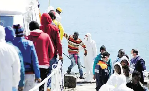  ?? Reuters ?? Contentiou­s issue Migrants disembark from an Italian Coast Guard boat as they arrive in the Sicilian harbour of Palermo on Wednesday.