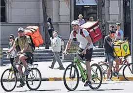  ?? (RAMIRO PEREYRA) ?? Bicivolado­res. Las calles se llenaron de jóvenes que trabajan en el reparto de alimentos en bicicleta. Todavía no tienen regulación.