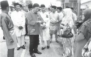  ??  ?? RICHAH: Mawan enggau Mohd Chee bela datai ngerichahk­a pengerami ‘Ramah Tamah’ Aidilfitri, di Kampung Sessang, kemari.