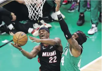  ?? MICHAEL DWYER, AP ?? Heat forward Jimmy Butler goes hard to the hoop against Celtics centre Robert Williams III during the second half of Game 7 of the Eastern Conference finals on Monday in Boston.