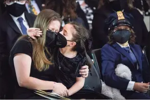  ?? Drew Angerer / Associated Press ?? Abigail Evans, 7, the daughter of the late U.S. Capitol Police officer William “Billy” Evans, embraces her mother, Shannon Terranova, left, during a memorial service as Evans lies in honor in the Rotunda at the U.S. Capitol on Tuesday.