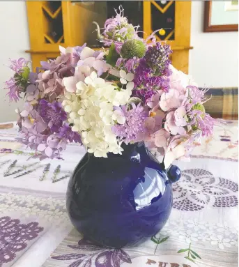  ?? ELIZABETH GOMEZ/THE WASHINGTON POST ?? In Winchester, Va., Elizabeth Gomez creates tabletop bouquets from flowers she grows in her garden. Gomez says working in the garden has been “a lifesaver” during the pandemic.