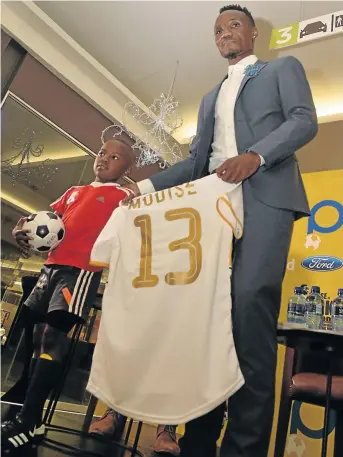  ?? / LEFTY SHIVAMBU / GALLO IMAGES ?? Teko Modise with a young fan during the launch of his book, ‘The Curse of Teko Modise’ in Rosebank on Tuesday.