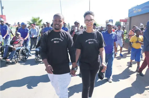  ?? Picture: Supplied ?? ‘COME WITH ME, BROTHER’. Kagiso Modupe, his wife, Liza, and residents walk through Katlehong before he is circumcise­d as part of the campaign.
