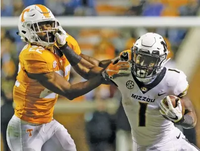  ?? STAFF PHOTO BY C.B. SCHMELTER ?? Missouri running back Tyler Badie stiff-arms Tennessee defensive back Micah Abernathy during the visiting Tigers’ 50-17 win Saturday at Neyland Stadium in Knoxville.
