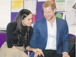  ??  ?? Prince Harry and his fiancée Meghan Markle speak with teachers and pupils at the Nottingham Academy in Nottingham, England on Friday.