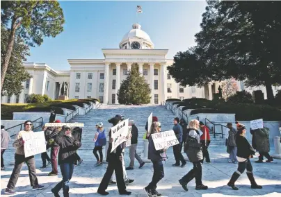  ?? PHOTO BY ALBERT CESARE/THE MONTGOMERY ADVERTISER VIA AP ?? Protesters march outside the Alabama Capitol building requesting that Electoral College delegates abstain from voting for President-elect Donald Trump on Monday in Montgomery, Ala. Alabama’s nine presidenti­al electors cast their ballots for Trump.