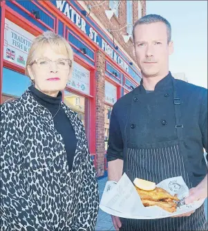  ?? MITCH MACDONALD/THE GUARDIAN ?? Water Street Fish and Chips waitress Brenda Marshall and chef Steve MacLure show the meal that the Charlottet­own restaurant has become known for in its six years of operating. The two are among a dozen year-round employees who will be affected when the business closes its doors at the end of this month.