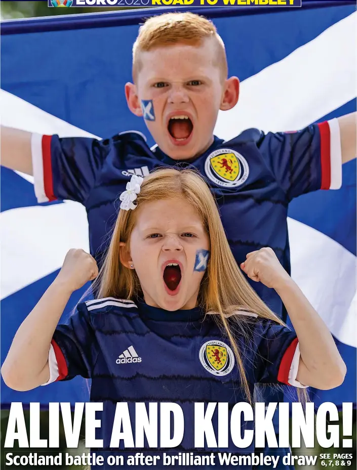  ??  ?? Wrapped in the flag: Two of the Tartan Army’s younger footsoldie­rs cheer on their team before last night’s crucial Euro 2020 clash with the Auld Enemy