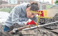  ?? EDUARDO LIMA/ STAR METRO ?? Julia Herbst, a researcher from Texas A&M, examines the artifacts discovered through condo constructi­on at CityPlace.