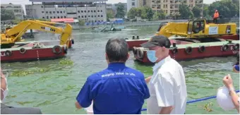  ?? PHOTOGRAPH COURTESY OF SMC ?? Beating flood scourge SMC President and CEO Ramon S. Ang (second from left in black cap) oversees San Miguel Corp.’s campaign to clean up the Pasig River that raised the waterway’s flood-carrying capacity. From just two to three meters deep at the start of the project, completed sections now have depths of up to five to six meters.