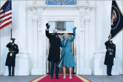  ?? (AP Photo/Alex Brandon, Pool) ?? President Joe Biden and first lady Jill Biden wave as they arrive at the North Portico of the White House on Wednesday in Washington.