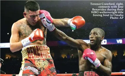  ??  ?? Terence Crawford, right, connects with Jose Benavidez during their WBO welterweig­ht title boxing bout in Omaha Photo: AP