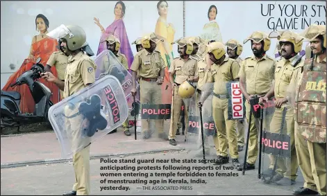  ?? — THE ASSOCIATED PRESS ?? Police stand guard near the state secretaria­t anticipati­ng protests following reports of two women entering a temple forbidden to females of menstruati­ng age in Kerala, India, yesterday.