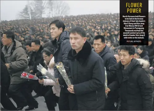  ?? PICTURE: AP PHOTO. ?? North Koreans hold flowers to be laid at the bronze statues of their late leaders Kim Il Sung and Kim Jong Il at Mansu Hill Grand Monument in Pyongyang. Thousands marked the seventh anniversar­y of the death of leader Kim Jong Il with visits to the statues.