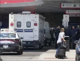  ?? TONY GUTIERREZ — THE ASSOCIATED PRESS ?? A traveler makes her way past emergency responders standing outside the ticketing and check in area at Dallas Love Field in Dallas on Monday.