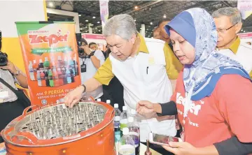  ??  ?? Ahamd Zahid (left) checks out ‘Aiskrim Goyang’ after opening the Halfest Asean 2017 at the Mines Internatio­nal Exhibition and Convention Centre in Kuala Lumpur. — Bernama photo