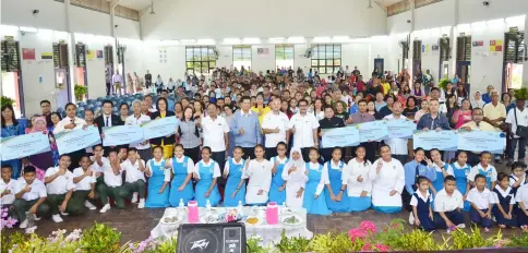  ??  ?? Majang (standing, eighth right) with students and others following the handing-over of school uniform vouchers by Yayasan Sarawak.