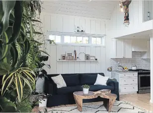  ??  ?? A living wall of plants brings gorgeous green texture to the bright, white living room. Van Sickle brought the teak tree-stump coffee table home from Bali.