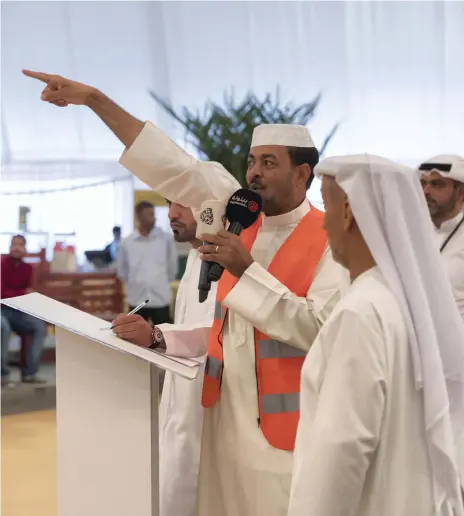  ?? Photos Antonie Robertson / The National ?? The auctioneer, Mohammed Ahmed, above, leads the sale of boxed and branded organic dates at the first Liwa auction