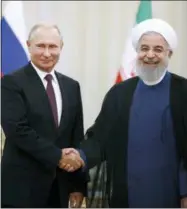  ?? EBRAHIM NOROOZI — THE ASSOCIATED PRESS ?? Iran’s President Hassan Rouhani, right, shakes hands with Russia’s President Vladimir Putin, in Tehran, Iran, Friday,