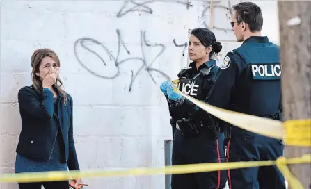  ?? NATHAN DENETTE THE CANADIAN PRESS ?? Toronto police talk to a woman after a van mounted a sidewalk killing 10 pedestrian­s and injuring another 15 in Toronto on Monday.