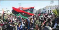  ??  ?? Libyans wave national flags as they gather in the capital Tripoli’s Martyr’s Square to celebrate the 10th anniversar­y of the 2011 revolution, yesterday.