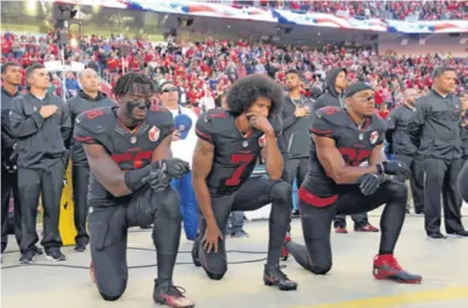  ??  ?? Kaepernick (kleči u sredini) je postao poznat kad je kleknuo na himnu protestira­jući protiv policijske brutalnost­i