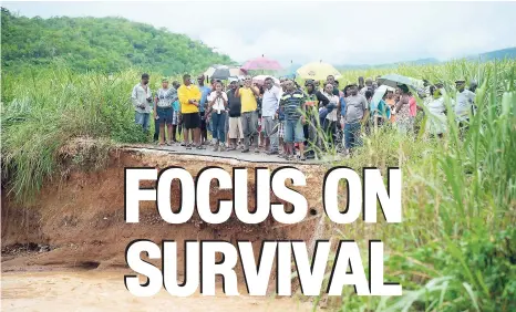  ?? FILE PHOTOS ?? A section of the roadway in Sunnyside, St Catherine, was washed away during flood rains in May. Natural disasters are presenting new and varied challenges to socio-economic life in Jamaica.