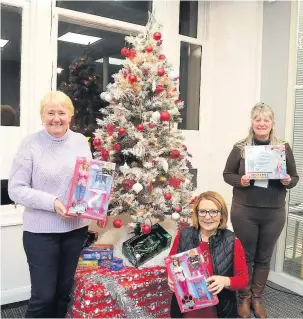  ??  ?? Depositing gifts Stay Connected toy appeal volunteers June Davenport, Patricia Rossi and Sandra Wright