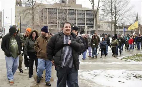  ?? Andy Colwell/Erie Times-News ?? Gun rally organizer Justin Dillon, center, of Erie, leads a gun rights walk in Erie on Feb. 23, 2013, during the Erie rendition of the "Day of Resistance" movement occurring across the country. Many attendees were showing their support for gun rights by carrying firearms openly, a practice that does not require a permit in Pennsylvan­ia except in Philadelph­ia. Mr. Dillon was central to overturnin­g an Erie ordinance that prohibited the carrying of firearms in city parks.