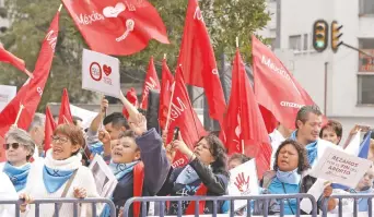  ??  ?? Con vestimenta blanca y azul, los asistentes a la manifestac­ión para expresar rechazo contra el aborto ondeaban pañuelos, algunos con un rosario que levantaban con el puño.