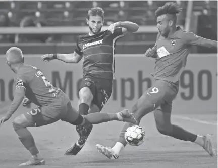  ?? JOE RONDONE/THE COMMERCIAL APPEAL ?? Memphis 901 FC'S Zach Carroll kicks the ball past Birmingham Legion FC'S Mikey Lopez, left, and JJ Williams at Autozone Park on Saturday, Oct. 3, 2020.